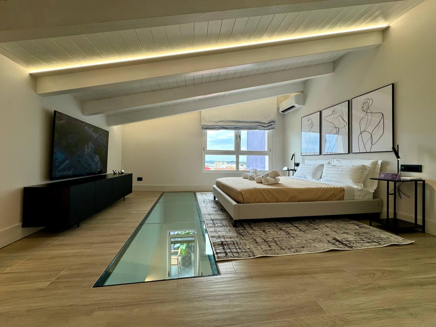 Large king-size bed with premium linen, custom-made pillows, and a quality mattress. The TV is 65".